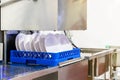 Close up white plate on basket in automatic dishwasher machine for industrial Royalty Free Stock Photo