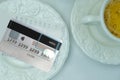 Close-up of white plate for money, credit card, Restaurant bill, cup of coffee, delicate pink flowers, dishes with food, the