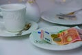 Close-up of a white plate for money, euro banknotes and coins, Restaurant bill, cup of coffee, delicate pink flowers, dishes with