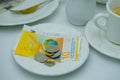 Close-up of white plate for money, Swiss francs banknotes and coins, Restaurant bill, cup of coffee, delicate pink flowers, dishes Royalty Free Stock Photo