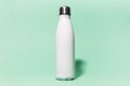 Close-up of white reusable steel stainless thermo water bottle isolated on background of aqua menthe color. Plastic free.