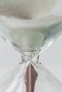 Close up white sand flowing of vintage wooden hourglass on white Royalty Free Stock Photo