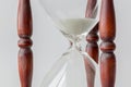 Close up white sand flowing of vintage wooden hourglass on white Royalty Free Stock Photo