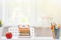 Close-up of a white schoolchild desktop. On the table is a stack of books. Light from the window. Blurred background Royalty Free Stock Photo