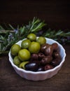 Plate with green and black olives and rosemary