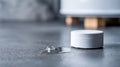 Close-up of white smart home sensor device on floor with water droplet and blurred background in modern interior Royalty Free Stock Photo