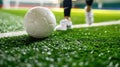 Close-up of a white soccer ball on artificial grass with player& x27;s feet in the background. Royalty Free Stock Photo