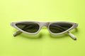 Close up  white sunglasses isolate on a green background Royalty Free Stock Photo
