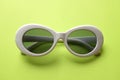 Close up  white sunglasses isolate on a green background Royalty Free Stock Photo