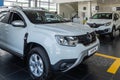 Close-up of white SUV Renault Duster car in showroom of Renault dealership. On right is Renault Kaptur SUV. Mega Adygea