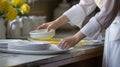 Close up of white tableware, girl washing dishes in bright industrial kitchen with yellow gloves