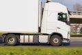 A close-up of a white truck with a semi-trailer is driving on the street. Motion blur Royalty Free Stock Photo