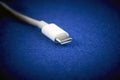 Close-Up of white USB Type-C cable on blue background. Royalty Free Stock Photo