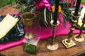 Close up of white vintage candelabrum on the wedding decorated table in the forest. Bouquet of pink flowers. Romantic dinner in th