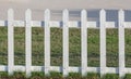 Close up the white wooden fence nearby pathway and green grass. Royalty Free Stock Photo