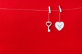 Close up of White wooden heart simbol and key on red paper background