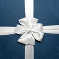 Close-up of white wrapping ribbon in shape of bow on blue gift box. Royalty Free Stock Photo