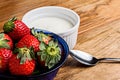 Close up yogurt and strawberries in a blue glass bowl on wooden table Royalty Free Stock Photo