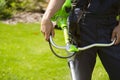 A close up of a white young man moving a lawn with a lawn mower in his hands Royalty Free Stock Photo