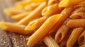 Close-up of whole wheat penne pasta scattered on a rustic wooden surface. Royalty Free Stock Photo