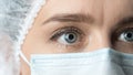 Close up widely opened eyes of doctor. Female doctor in protective mask with beautiful eyes close up.