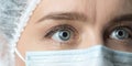 Close up widely opened eyes of doctor. Female doctor in protective mask with beautiful eyes close up. Royalty Free Stock Photo