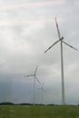 Close up of wind turbine in rural Germany view from window of moving train in summer with cloudy and dark sky background. Royalty Free Stock Photo