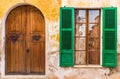 Green open window shutter and wooden front door of mediterranean house Royalty Free Stock Photo