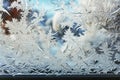 A close up of a window with water drops, frost and snow figures on an icy window in winter