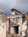 close up of the windows of a collapsing abandoned roofless house with broken shutter and grey sky Royalty Free Stock Photo