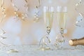 A close up of wine flutes filled with champagne and wedding bands inside the flute, against a bokeh background. Royalty Free Stock Photo