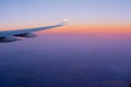 Close Up of Wing of an Airplane in flight on Colored Clear Sky Background during Sunrise Royalty Free Stock Photo