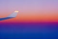 Close Up of Wing of an Airplane in flight on Colored Clear Sky Background during Sunrise Royalty Free Stock Photo