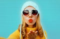 Close up winter portrait pretty woman blowing red lips sending sweet air kiss stretching hand for taking selfie Royalty Free Stock Photo