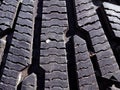 Close-up of winter tire tread with stuck rock