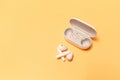 Close-up of wireless earbuds with charger case on pastel yellow background Royalty Free Stock Photo