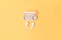 Close-up of wireless earbuds with charger case on pastel yellow background Royalty Free Stock Photo