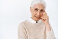 Close-up wise old lady with grey hair teaching kids important lesson, touching temple with finger to tell think before Royalty Free Stock Photo