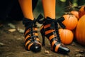 Close up of a witches shoes and legs with orange and black stripes