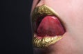 Close up woma face with gold lips. Gold paint on mouth. Golden lips. Luxury gold lips make-up. Golden lips with creative