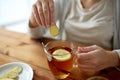 Close up of woman adding ginger to tea with lemon Royalty Free Stock Photo