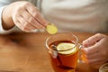 Close up of woman adding ginger to tea with lemon Royalty Free Stock Photo