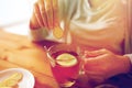 Close up of woman adding ginger to tea with lemon Royalty Free Stock Photo