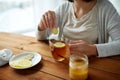 Close up of woman adding ginger to tea with lemon Royalty Free Stock Photo