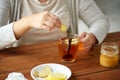 Close up of woman adding ginger to tea with lemon Royalty Free Stock Photo