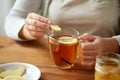 Close up of woman adding ginger to tea with lemon Royalty Free Stock Photo