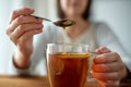 Close up of woman adding honey to tea with lemon Royalty Free Stock Photo