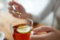 Close up of woman adding honey to tea with lemon Royalty Free Stock Photo