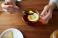 Close up of woman adding honey to tea with lemon Royalty Free Stock Photo