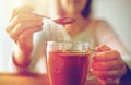 Close up of woman adding honey to tea with lemon Royalty Free Stock Photo